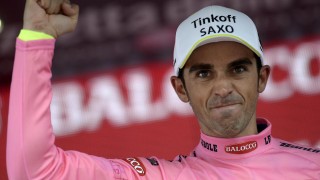 ÆRLIG OPPTREDEN? Alberto Contador var tydelig fornøyd med å motta den rosa ledertrøya etter den 16. giroetappen til Aprica forrige tirsdag. Men andre stusset over spanjolens hjulskifte. Foto: Fabio Ferrari / REUTERS / NTB scanpix