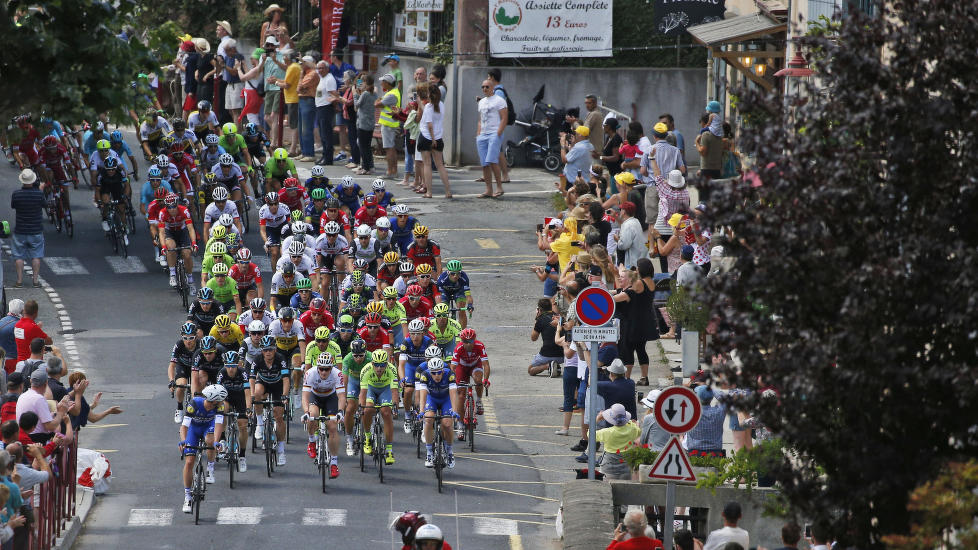 UBERØRT: Tour de France-feltet fotografert på vei gjennom en landsby på onsdagens 162,5 kilometer lange etappe til Montpellier. Foto: Christophe Ena / AP Photo / NTB scanpix