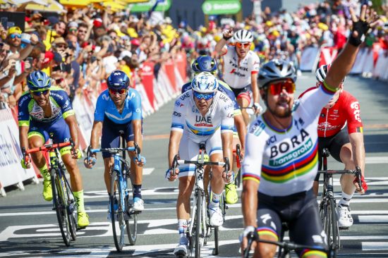 NY KAMP: Kristoff (bak i hvit) ender på femteplass i det slovakiske Peter Sagan løfter hånden i været i mål etter andre etappe i Tour de France i La Roche-sur-Yon søndag. Torsdag venter nye muligheter. Foto: Heiko Junge / NTB scanpix