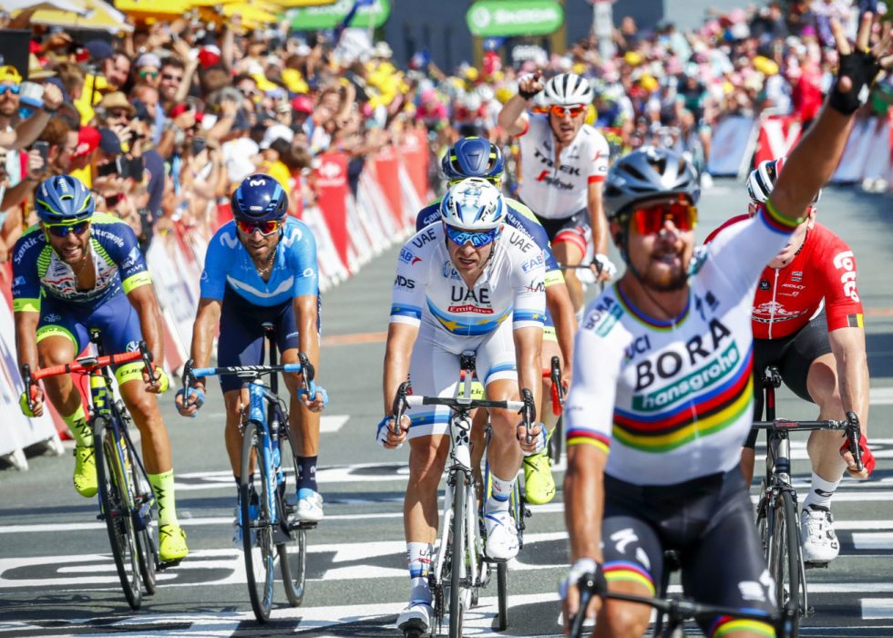 NY KAMP: Kristoff (bak i hvit) ender på femteplass i det slovakiske Peter Sagan løfter hånden i været i mål etter andre etappe i Tour de France i La Roche-sur-Yon søndag. Torsdag venter nye muligheter. Foto: Heiko Junge / NTB scanpix